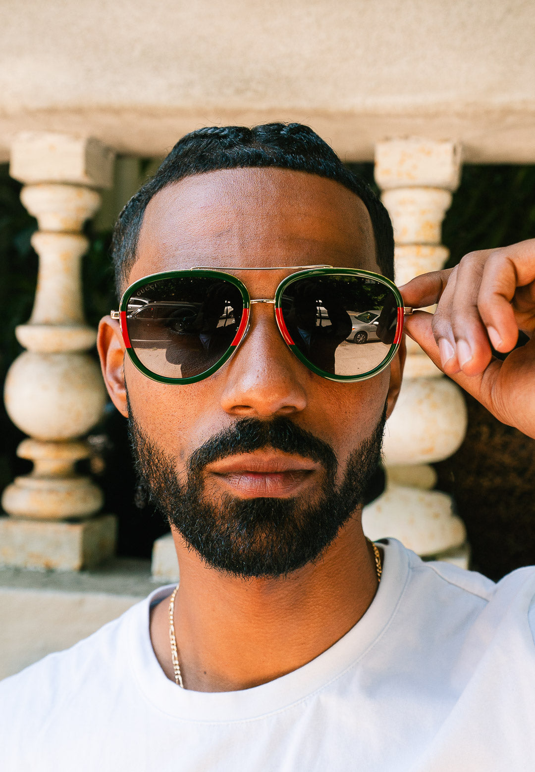 Man wearing green sunglasses with a neutral background